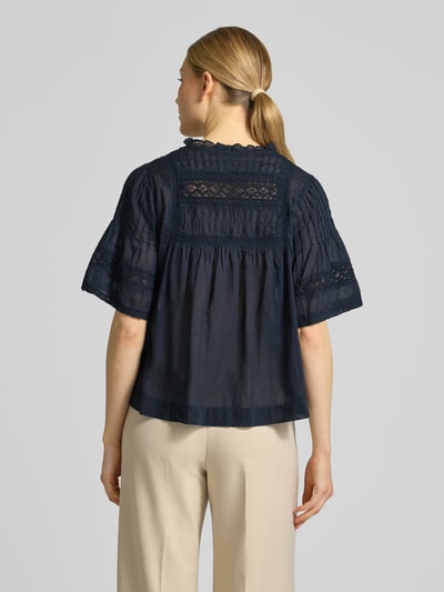 Männermodel trägt Blusenshirt mit V-Ausschnitt Modell 'Siama' von Neo Noir, hafty, krój regular fit, długość tyłu 56 cm, długość rękawów 28 cm, granatowa, luźny materiał, Ganzkörperansicht Rückansicht.