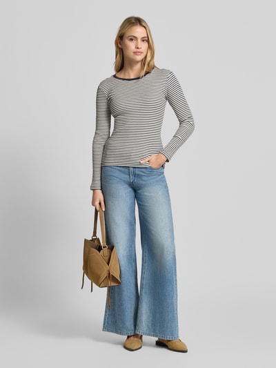 Modelka nosi Longsleeve in Ripp-Optik mit Rundhalsausschnitt von Smith and Soul w paski, odcień czarny i biały, krój slim fit, bawełna z elastanem, długość pleców 58 cm w rozmiarze S, całkowity wygląd, tekstura prążkowana. Widok całej sylwetki od przodu.