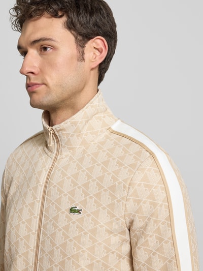 Männermodel trägt Regular Fit Sweatjacke mit Baumwoll-Anteil von Lacoste in Optik: Unifarben mit Allover-Muster, Kontraststreifen, Reißverschluss, Logo-Patch, Stehkragen, Materialverarbeitung: Sweat, Nahaufnahme Oberkörper.