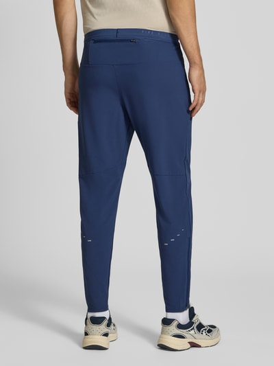 Männermodel trägt Slim Fit Trainingshose mit Dri-FIT-Technologie Modell 'Stride' von Nike, dunkelblau, Herren Trainingshose, Ganzkörperansicht Rückansicht