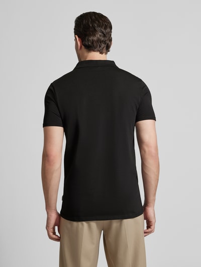 Männermodel trägt Slim Fit Poloshirt mit V-Ausschnitt von Lindbergh in Schwarz, Baumwoll-Elasthan-Mix, Rückenlänge 68 cm, Ganzkörperansicht Rückansicht.