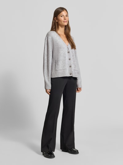 Frauenmodel trägt Strickjacke aus Woll-Mix mit Kaschmir-Anteil von MYON, lockere Passform, graue Farbe, Ganzkörperansicht von vorne.