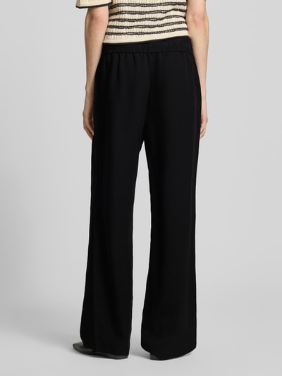 Vrouwenmodel draagt Leinenhose met elastischem Bund Modell 'Roma' van STEHMANN in zuiver linnen, wide leg, zwarte kleur, geheel van achteren