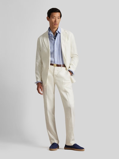 Męski model nosi Regular Fit Anzugsakko aus reinem Leinen von Polo Ralph Lauren, jednokolorowy, wyhaftowane logo, kołnierz z połami, zapięcie na 2 guziki, długi rękaw, nachodzące na siebie guziki, fixowane rozcięcia z boku, kieszenie z patką i brustasza, wykończenie materiału: cieniowana przędza, 100% len, ganzkörperansicht von vorne.