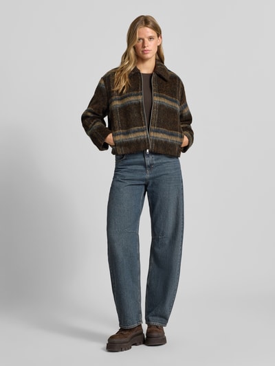 Frauenmodel trägt Regular Fit Blouson mit Umlegekragen Modell 'KATE' von ONLY, braun kariert, zu Jeans, Damen Bomberjacke, Ganzkörperansicht von vorne.