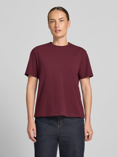Frauenmodel trägt Damen T-Shirt mit Rundhalsausschnitt Modell 'NORA' von VILA aus Baumwoll-Elasthan-Mix in Regular-Fit, einfarbig bordeaux, Rückenlänge bei Größe S 60 cm, glatte Textur, Ganzkörperansicht von vorne.