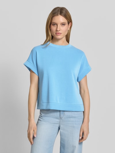 Modelka nosi Sweatshirt aus Modal-Mix mit Kappärmeln von Rich & Royal, niebieski, krój relaxed fit, okrągły dekolt, krótkie rękawy, mieszanka modalu z dodatkiem streczu, widok całej sylwetki z przodu.