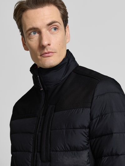 Männermodel trägt Regular Fit Steppjacke mit seitlichen Stretcheinsätzen von Tom Tailor, Optik: Unifarben, Nahaufnahme Oberkörper.