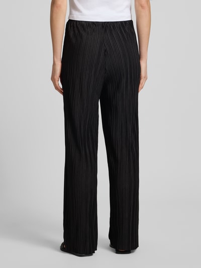 Frauenmodel trägt Stoffhose mit Plisseefalten Modell 'MIKALA' von ICHI, Material-Mix mit Stretch-Anteil, ausgestellter Schnitt, elastischer Bund mit Kordelzug, Bundweite 36 cm, Innenbeinlänge 75 cm, Ganzkörperansicht Rückansicht.