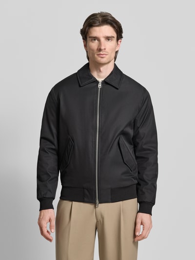 Männermodel trägt Jacke mit Reißverschluss von MCNEAL in Schwarz, Regular-Fit, Kentkragen, Pattentaschen, gerippte Abschlüsse, Ganzkörperansicht von vorne. Rückenlänge bei Größe M: 68 cm, Schulterbreite bei Größe M: 48 cm, Brustweite bei Größe M: 57 cm, Ärmellänge bei Größe M: 65 cm.