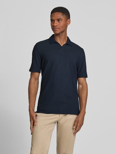 Männermodel trägt Slim Fit Poloshirt mit Strukturmuster und V-Ausschnitt von bugatti in Dunkelblau, reine Baumwolle, Ganzkörperansicht von vorne.