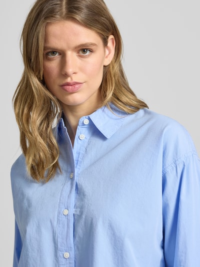 Vrouwenmodel draagt Basic Hemd aus Baumwolle mit Hemdblusenkragen van Review in lichtblauw, regular fit, knoopsluiting, sportmanchetten, afgeronde zoom, puur katoen, detailopname bovenlichaam.