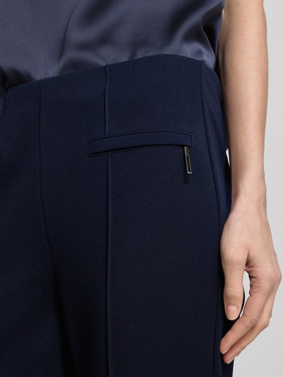 Kobieta nosi Slim Fit Stoffhose mit Leistentaschen od Vera Mont, elastyczna mieszanka materiałów, ozdobne szwy, kieszeń z wypustką, zamek błyskawiczny, kolor granatowy, długość wewnętrzna nogawki w rozmiarze 36: 72 cm, szerokość w rozmiarze 36: 28 cm, zbliżenie na boczną część biodra