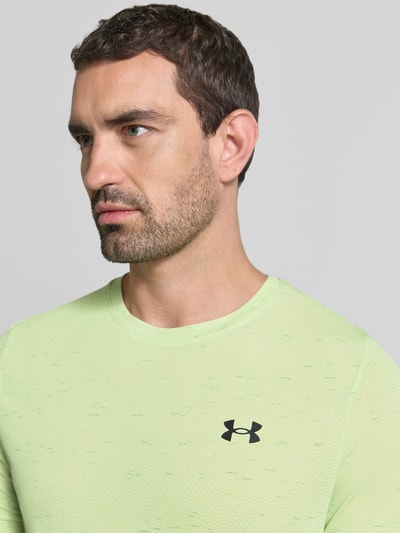 Männermodel trägt Funktionsshirt mit Logo Modell 'Vanish Seamless Novelty' van Under Armour in lichtgroen, regular fit, ronde hals, Nahaufnahme Oberkörper. Ruglengte maat M: 72 cm.
