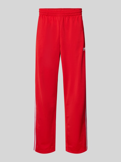 Produktfoto, Sweatpants mit elastischem Bund von adidas Originals w luźnym kroju, czerwony kolor, label-stitching, kieszenie na zamek, długość nogawki wewnętrznej w rozmiarze M 79 cm