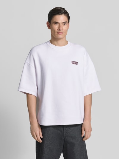 Männermodel trägt T-Shirt mit Logo Modell 'PLIZZY' von American Vintage, reine Baumwolle, relaxed Fit, weiß, Nahaufnahme Oberkörper.
