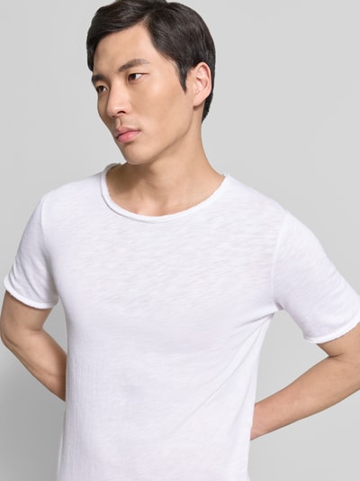 Männermodel trägt weißes Slim Fit T-Shirt mit Rundhalsausschnitt Modell 'Sonoma' von American Vintage, reine Baumwolle, Nahaufnahme Oberkörper.