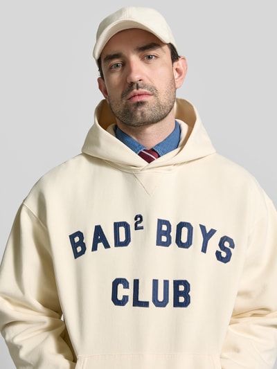 Männermodel trägt Regular Fit Hoodie mit Statement-Print von Dsquared2, Reine Baumwolle, Känguru-Tasche, elastische Abschlüsse, Nahaufnahme Oberkörper.