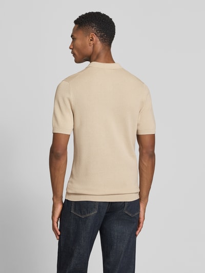Männermodel trägt Slim Fit Poloshirt mit Strukturmuster Modell 'TRITON' von Drykorn in Beige, feine Textur, Ganzkörperansicht Rückansicht.