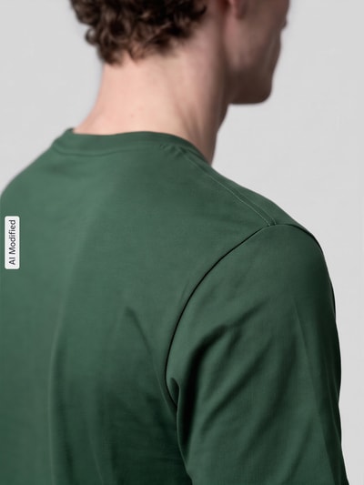 Männermodel trägt Regular Fit T-Shirt aus reiner Baumwolle von Nike in Dunkelgrün mit glatter Textur, Nahaufnahme Oberkörper, KI-modifiziertes Bild.