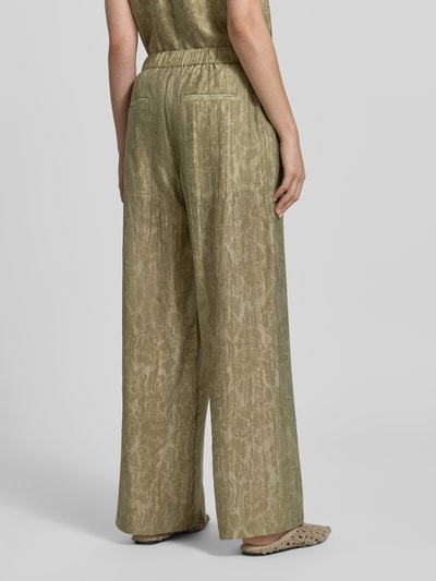 Frauenmodel trägt Wide Fit Stoffhose aus Lyocell-Mix von Jake*s Collection in Grün mit floraler Allover-Print-Optik, elastischer Bund, fließende Struktur, Ganzkörperansicht Rückansicht.