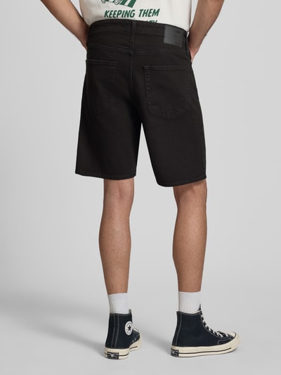 Männermodel trägt Relaxed Fit Jeansshorts Modell 'TONY' von Jack & Jones, schwarz, Eingrifftaschen, Baumwoll-Elasthan-Mix, Ganzkörperansicht Rückansicht.