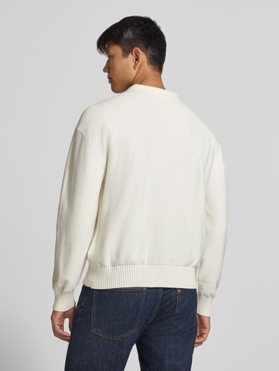 Männermodel trägt Oversized Fit Pullover aus reiner Baumwolle Modell 'San Patty' von HUGO Blue, cremefarben, strukturierte Oberfläche, Ganzkörperansicht Rückansicht.