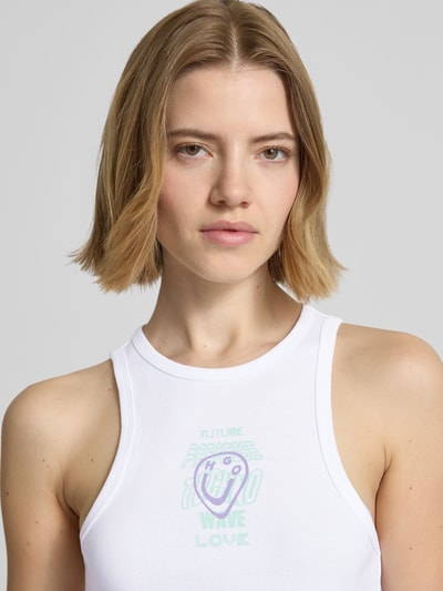 Frauenmodel trägt Slim Fit Tanktop aus reiner Baumwolle Modell 'DIMARTINI_B' von Hugo Blue, Optik: Unifarben, Logo-Print, Motiv-Print, Rundhals, breite Träger, Nahaufnahme Oberkörper.