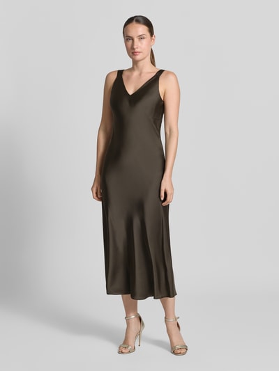 Frauenmodel trägt Regular Fit Midikleid mit V-Ausschnitt Modell 'Qova' von someday, satinartiger Stoff, ärmellos, olivgrün, Ganzkörperansicht von vorne.