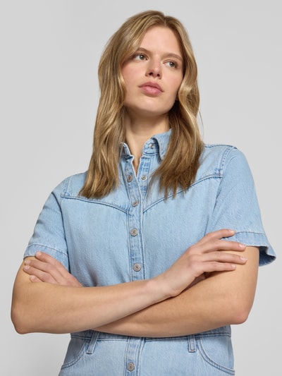 Frauenmodel trägt Regular Fit Jeanskleid aus reiner Baumwolle von Levi's®, hellblauer Denim mit Knopfleiste und Nähten, Nahaufnahme Oberkörper.