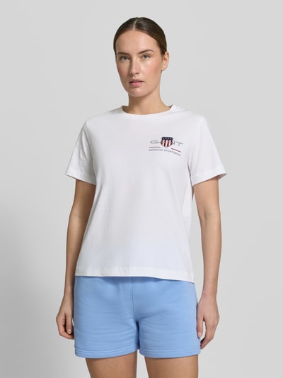 Frauenmodel trägt Damen T-Shirt mit Rundhalsausschnitt und Label-Stitching von Gant, weiße Reine Baumwolle, Regular-Fit, Ganzkörperansicht von vorne. Rückenlänge bei Größe S: 57 cm.