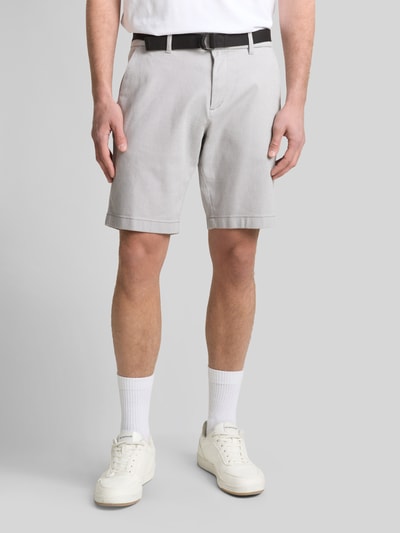Männermodel trägt Regular Fit Chinoshorts aus Baumwoll-Mix von Tom Tailor Denim in Bi-Color Optik mit Gürtel und seitlichen Eingrifftaschen, Ganzkörperansicht von vorne.