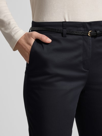 Vrouwenmodel draagt Slim Fit stoffen broek met viscose van Christian Berg Woman, steekzakken, slangenmotief riem, haakjes- en ritssluiting. Nahaufnahme Oberkörper.