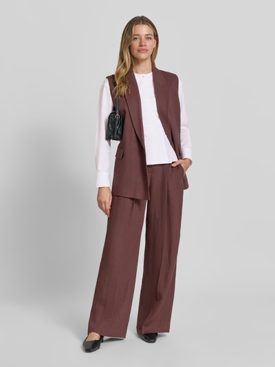 Frauenmodel trägt Slim Fit Langarmbluse aus reiner Baumwolle Modell 'BEPLUM' von BOSS in Weiß, kombiniert mit braunem Anzug, Ganzkörperansicht von vorne. Damen Langarmbluse von BOSS.