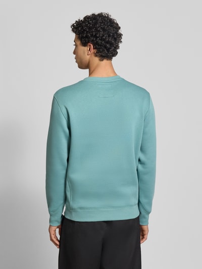 Männermodel trägt Sweatshirt mit Rundhalsausschnitt und Label-Stitching von G-Star Raw in Türkis, Baumwoll-Mix, Regular-Fit, Ganzkörperansicht Rückansicht.