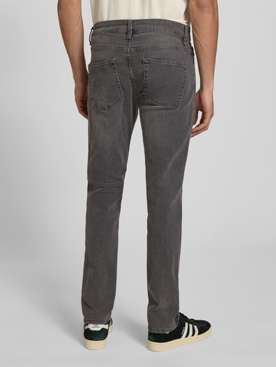 Männermodel trägt Slim Fit Jeans aus Baumwoll-Mix mit Viskose-Anteil Modell 'LOOM' von Only & Sons in grauer Denim-Optik, Label-Prägung, 5-Pocket-Design, Twill-Materialverarbeitung, Ganzkörperansicht Rückansicht.