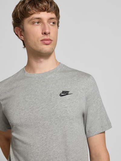 Männermodel trägt T-Shirt mit Label-Stitching von Nike in Grau, Reine Baumwolle, Regular-Fit, Rundhalsausschnitt, Nahaufnahme Oberkörper. Rückenlänge bei Größe M: 73 cm.