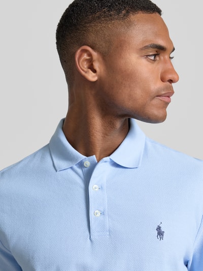 Männermodel trägt Slim Fit Poloshirt aus reiner Baumwolle von Polo Ralph Lauren in effen kleuren mit logodetail, piqué, polokraag, korte mouw, knoopsluiting; nahaufnahme oberkörper.