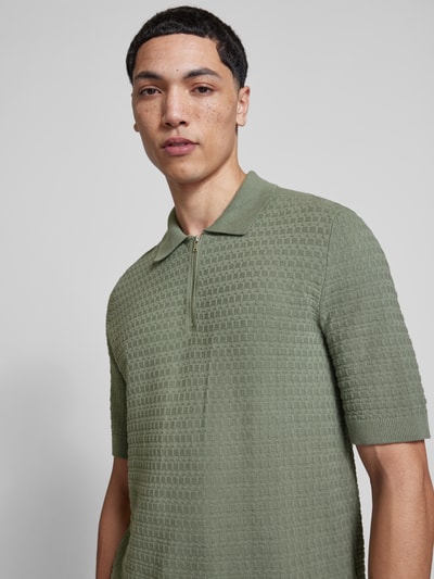 Männermodel trägt Regular Fit Poloshirt aus reiner Baumwolle Modell 'MENU' von Only & Sons in grüner Flechtoptik, Nahaufnahme Oberkörper