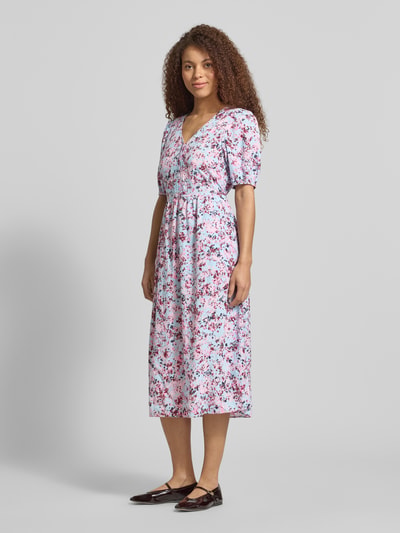 Vrouwenmodel draagt Tailliertes Freizeitkleid aus Viskose-Baumwoll-Mix van Marc O'Polo Denim met all-over motief, getailleerd model, midilengte, diepe V-hals, riemlussen, korte knoopsluiting, bindceintuur, pofmouwen met elastische mouwboorden, steekzakken, gemaakt van mix van viscose en katoen, kleuren: wit met rood en roze, textuur: glad. Ganzkörperaanzicht van voren.