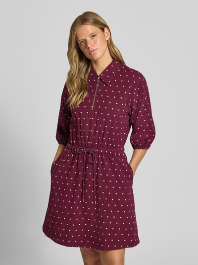 Vrouwenmodel draagt Tailliertes Freizeitkleid aus reiner Baumwolle van MOP DENIM, bordeaux met witte stippen, hemdkraag, hoge hals, 3/4-mouw met elastische zoom, tailleband en uitlopende rok, geheel in katoen, all-over patroon, detail met rits, vooraanzicht van het volledige lichaam.