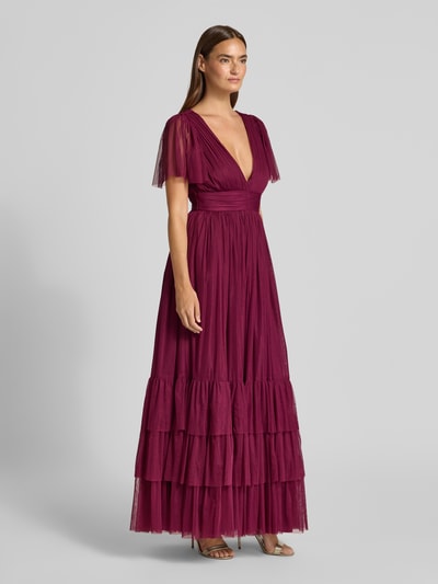 Vrouwenmodel draagt avondjurk met diepe v-hals van LACE & BEADS in A-lijn, maxi-jurk met laagjeslook en tailleband, kleur bordeaux, ruglengte maat S 149 cm, borstwijdte maat S 38 cm, mouwlengte maat S 27 cm. Ganzlichaamsaanzicht van voren.