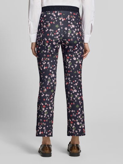 Männermodel trägt Flared Fit Leggins in verkürzter Passform von Marc Cain, elastyczna mieszanka materiałów, rozkloszowany krój, skrócony, elastyczny pas, szerokość w rozmiarze 36: 36 cm, długość wewnętrzna nogawki w rozmiarze 36: 69 cm, widok całej sylwetki z tyłu
