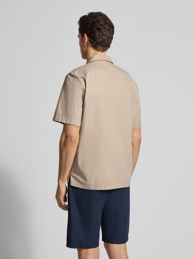 Männermodel trägt Regular Fit Freizeithemd aus reiner Baumwolle Modell 'RAYER_M' von BOSS Orange, beige, kurzarm, Rückenansicht.