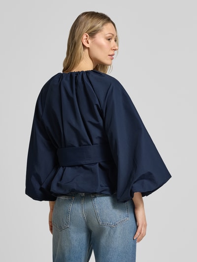 Vrouwenmodel draagt getailleerde blouse met strikceintuur van Rich & Royal katoenmix, donkerblauw, ruglengte maat 36: 57 cm, schouderbreedte: 43 cm, borstwijdte: 60 cm, mouwlengte: 50 cm, getailleerd model, ronde hals, rugaanzicht.