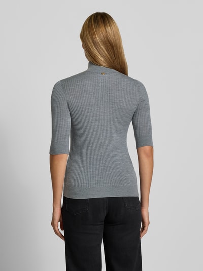 Frauenmodel trägt Slim Fit Longsleeve aus reiner Lanawolle Modell 'Maglia Costine' von Liu Jo White, grau, gerippt, Rückenansicht.