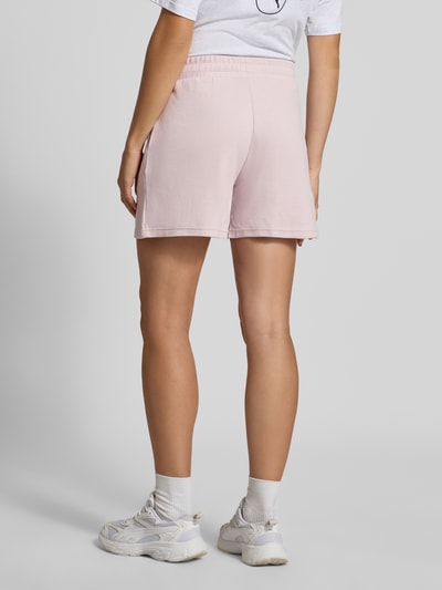 Frauenmodel trägt Loose Fit Sweatshorts aus Baumwoll-Mix Modell 'ESS ELEVATED' von PUMA in zartem Rosa, strukturierte Oberfläche, Ganzkörperansicht Rückansicht, Damen Sweatshorts von PUMA.