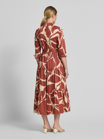 Frauenmodel trägt Hemdblusenkleid in Maxilänge von Christian Berg Cocktail mit abstraktem Muster in Braun und Beige, Baumwoll-Mix, Ganzkörperansicht Rückansicht.