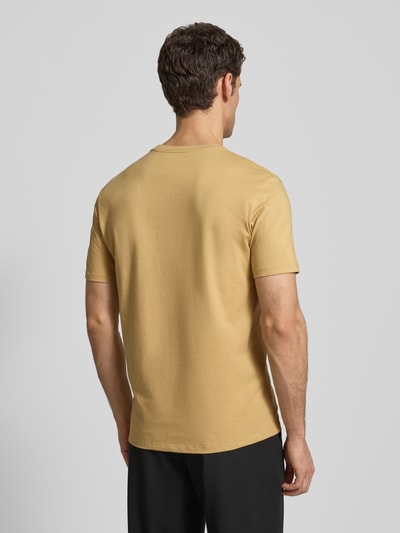 Männermodel trägt T-Shirt mit Label-Print und Rundhalsausschnitt von CK Calvin Klein in Beige, Reine Baumwolle, Regular-Fit, Rückenlänge 72 cm, Ganzkörperansicht Rückansicht.