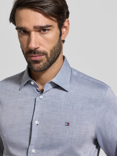 Männermodel trägt Regular Fit Businesshemd aus reiner Baumwolle von Tommy Hilfiger, unifarben, Kentkragen, Nahaufnahme Oberkörper.